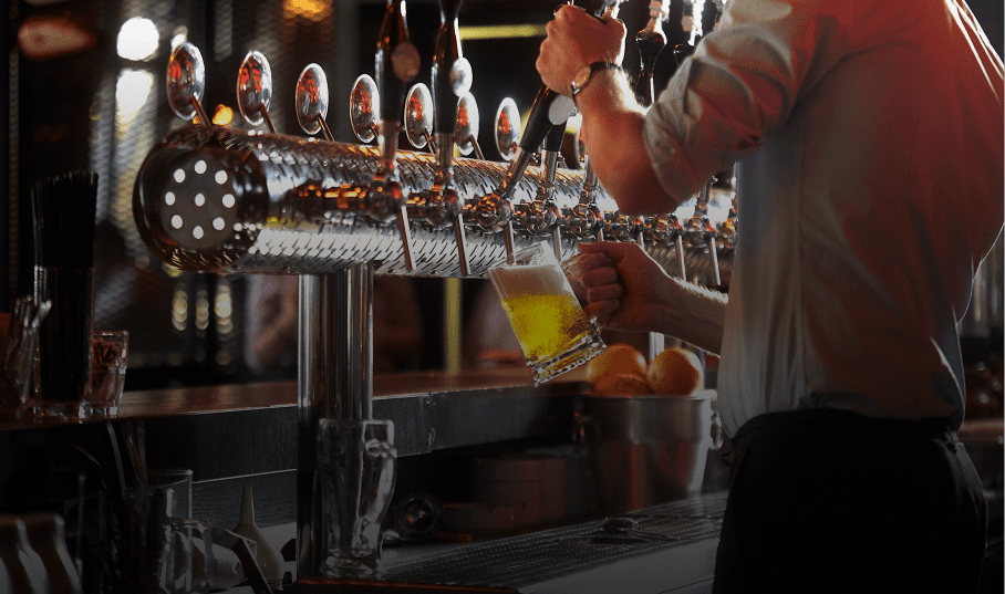 Bartender pouring beer from tap handles.