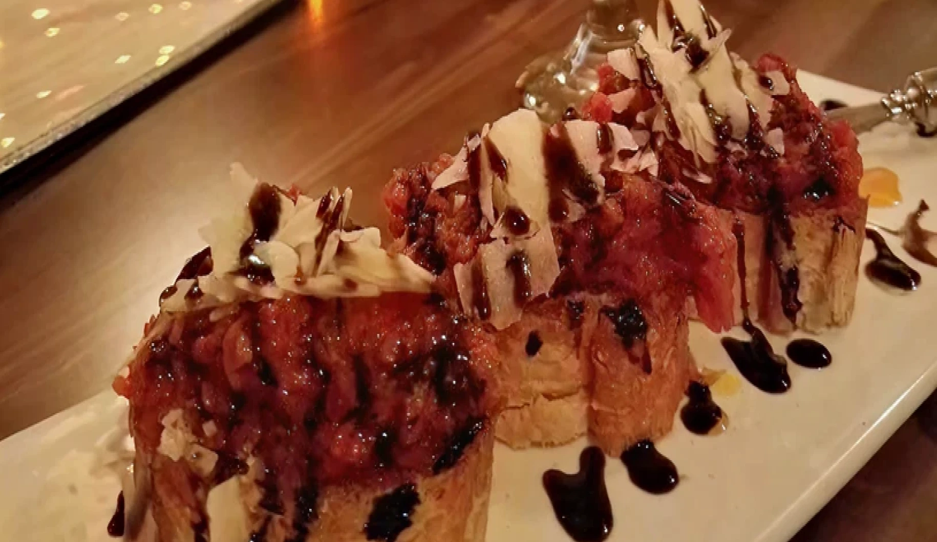 Bruschetta topped with tomatoes and balsamic glaze.